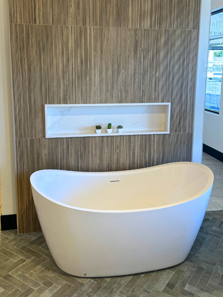 freestanding bathtub with tile flooring and tiled bath surround