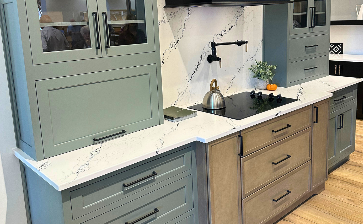 White marble countertops in a kitchen display with green and natural countertops